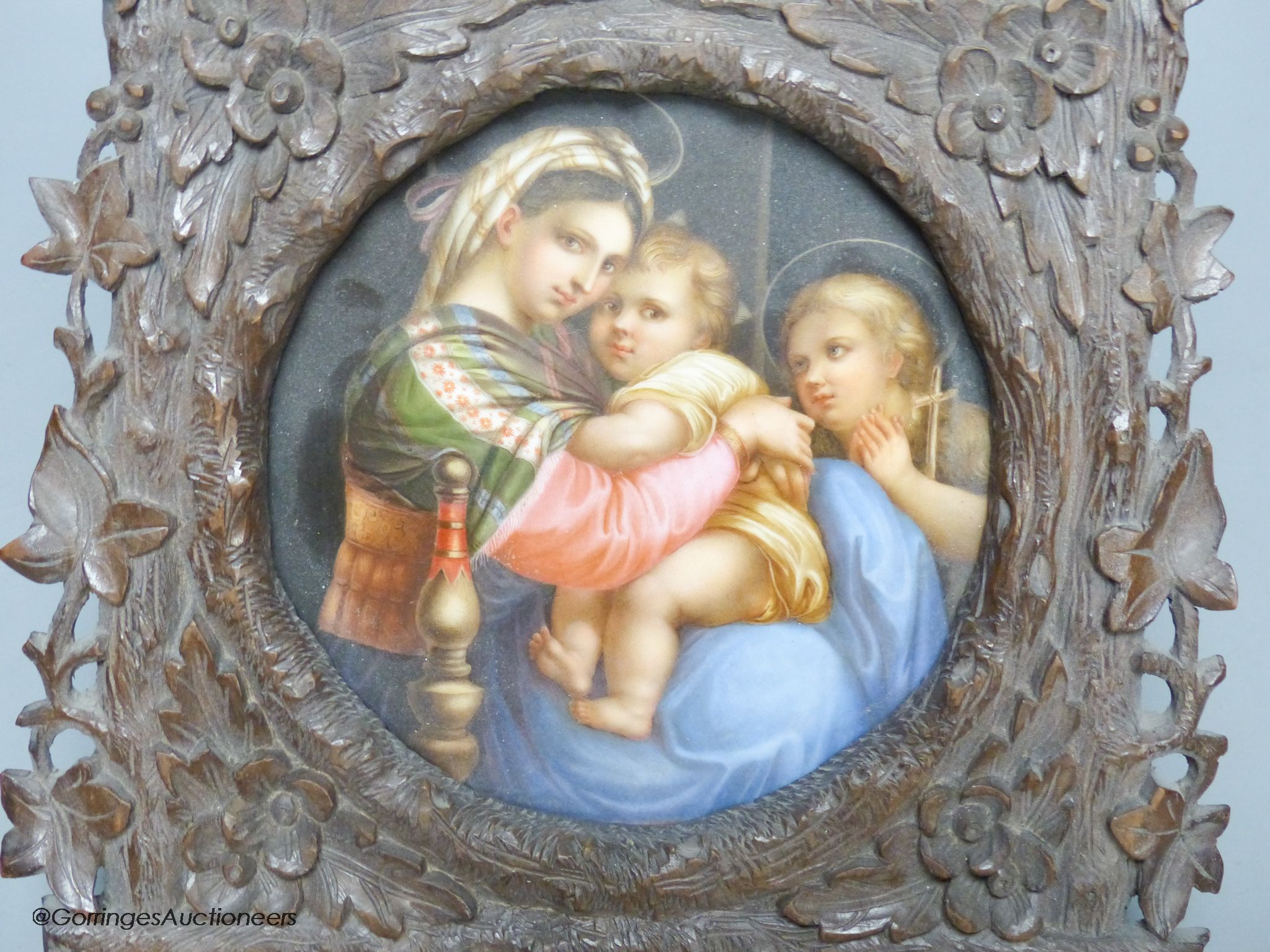 A late 19th century Paris porcelain plaque, depicting Madonna della Sedia, in Black Forest carved frame, width 19cm height 25cm overall